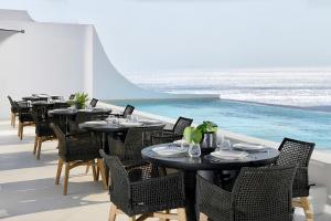 a restaurant with tables and chairs and a pool at Million Stars Mykonos, Iconic by Design in Mikonos