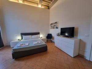a bedroom with a bed and a flat screen tv at 35 Rooms Palazzo Buoninsegni in Colle Val D'Elsa