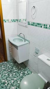a white bathroom with a toilet and a sink at Casa de Campo - Recanto Arvorecer in São José dos Pinhais