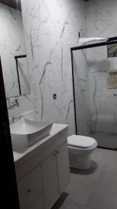 a white bathroom with a sink and a toilet at Casa Ampla Jd Primaveras in Sinop +10 photos