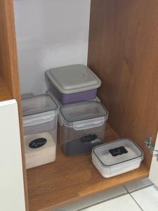 three plastic containers sitting on a shelf in a closet at Studio Friends - Centro BH - Ótima localização in Belo Horizonte