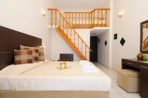 a bedroom with a large bed and a staircase at Kythera Irida in Agia Pelagia