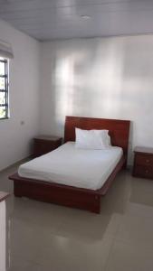 a bedroom with a bed with white sheets and pillows at Casa amplia en el Espinal, in El Espinal