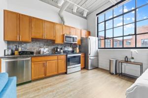 a kitchen with wooden cabinets and stainless steel appliances at 306-Urban Blissful Oasis Close to DT Parking in Cleveland +14 photos