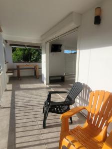 a porch with two chairs and a pool table at Le Triton in Deshaies