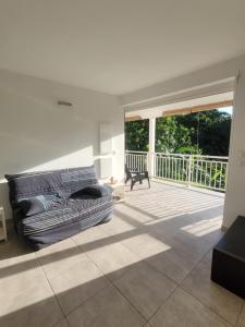 a living room with a couch and a balcony at Le Triton in Deshaies