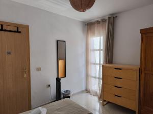 a bedroom with a bed and a dresser and a window at Acogedoras Habitaciones Privadas zona Costera Wifi in Morro del Jable