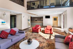 a living room with couches and red chairs at Best Western Plus Osoyoos Hotel & Suites in Osoyoos
