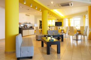 a restaurant with yellow walls and tables and chairs at Kythera Irida in Agia Pelagia