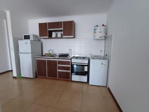 a kitchen with white appliances and brown cabinets at B&B Mono Ambiente in Concordia