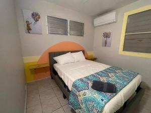 a small bedroom with a bed with an orange headboard at Relaxing Retreat for 5 Close to Beach & Airport in Carolina