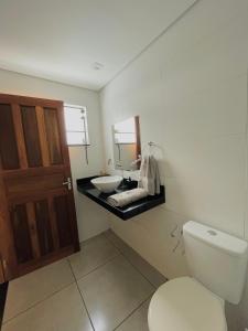 a bathroom with a white toilet and a sink at Casa aconchegante em São João del Rei in São João del Rei