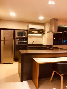una cucina con frigorifero ed elettrodomestici in acciaio inossidabile di Apartamento Premium Praia do Forte a Cabo Frio