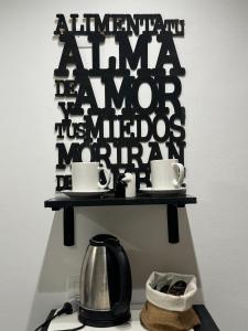 ein Regal mit einer Kaffeekanne und Tassen darauf in der Unterkunft Hermoso Departamento en el corazón del centro santiagueño a 100 metros de la plaza principal, con estacionamiento privado in Santiago del Estero