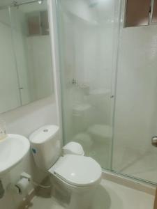 a white bathroom with a toilet and a shower at apartamento Amazilia en alameda del rio in Barranquilla