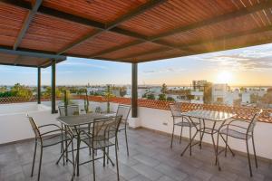a patio with tables and chairs on a balcony at Pineda Suite #102 two blocks from the Malecon in La Paz