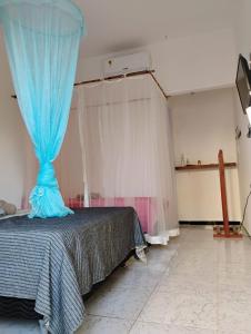 a bedroom with a bed with a blue curtain at Pousada Obedemar - Taipu de fora, Barra Grande, Ba in Barra Grande