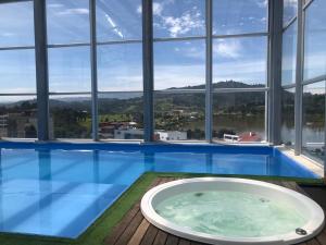 a jacuzzi tub in a building with a view at Lujoso Apartamento Cerca al Lago Sochagota en Paipa in Paipa