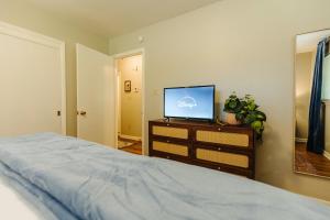 a bedroom with a bed and a flat screen tv at Centrally Located 2 King Bed Midtown Memphis 2362 in Memphis