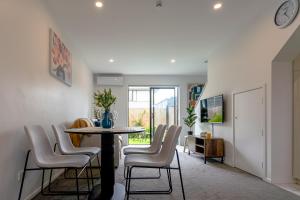a living room with a table and chairs at Modern 2 Bedroom Townhouse in CBD With Parking! Sleeps 5 in Christchurch