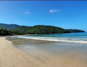 einen Strand mit Meer und Bäumen im Hintergrund in der Unterkunft Soul Shine Beach House in Bacungan + 5 Fotos