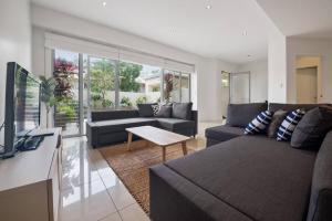 a living room with a couch and a table at 4 Bed Townhouse 200m to the Beach in Alexandra Headland