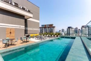 una piscina con sedie e tavoli all'interno di un edificio di Studio Zenith a San Paolo