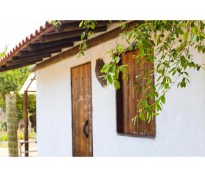 a small white house with a wooden door at Suíte Istambul Villas de São Jorge in Trancoso