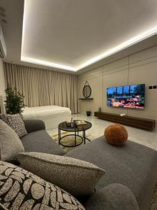 Una sala de estar con un sofá y un televisor. en استديو فندقي - مودرن فاخر كبير جدا, en Riad