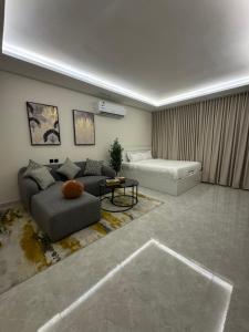 una sala de estar con un sofá y una mesa en استديو فندقي - مودرن فاخر كبير جدا, en Riad