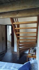 a wooden staircase in a room with a bed at Casa Curva in Baependi