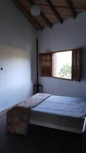 a bedroom with a bed and a window at Casa Curva in Baependi +44 photos