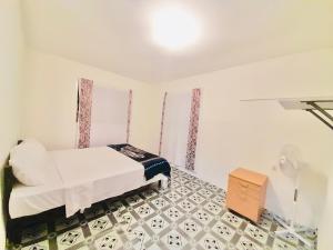 ein weißes Schlafzimmer mit einem Bett und einer Kommode in der Unterkunft Double Twin Private Room - Tonga Horizon Cottage in Nuku‘alofa