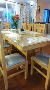 a dining room table and chairs with a table and flowers at Departamento Jerry in Cochabamba