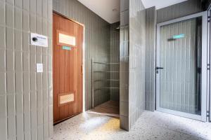 bagno con porta e cabina doccia di Studio Zenith a San Paolo