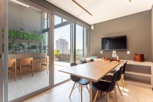 una sala da pranzo con tavolo e sedie in legno di Studio Zenith a San Paolo