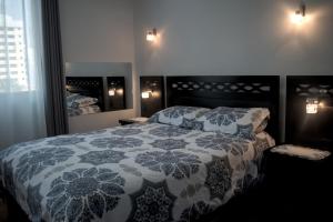 a bedroom with a bed with a blue and white quilt at Departamento Jerry in Cochabamba