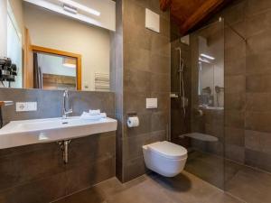 een badkamer met een wastafel, een toilet en een douche bij Chalet Lengberg B1 in Niedernsill +29 foto's