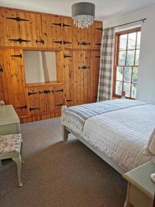 a bedroom with a bed and a window and a chandelier at Historic peaceful cottage in town centre! in Barnard Castle