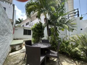 a patio with a table and chairs and a palm tree at NEW MORINGA in Las Terrenas