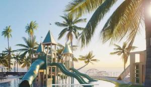 un toboggan aquatique dans un complexe hôtelier avec des palmiers dans l'établissement Porto Alto Resort - Porto de Galinhas, à Porto de Galinhas 18 autres photos