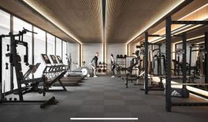 une salle de sport avec des rangées de machines et un homme en arrière-plan dans l'établissement Porto Alto Resort - Porto de Galinhas, à Porto de Galinhas