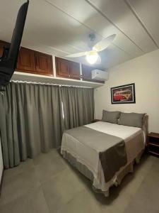 una camera da letto con un letto e un ventilatore a soffitto di Guarajuba Summer Flat - 110 - Apartamento Inteiro a Camassari