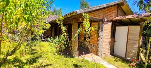 a brick house with a white door in a yard at Inti Samay in Ibarra