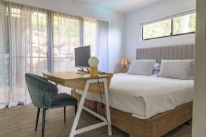 Un dormitorio con una cama y un escritorio con una computadora. en Panorama 9 & Free Buggy Hamilton Island, en Hamilton Island 17 fotos más