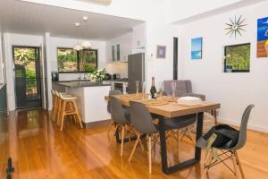 Un comedor y una cocina con mesa y sillas. en Panorama 9 & Free Buggy Hamilton Island, en Hamilton Island