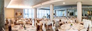a banquet hall with white tables and chairs at Hotel Le Ginestre in Roccacasale