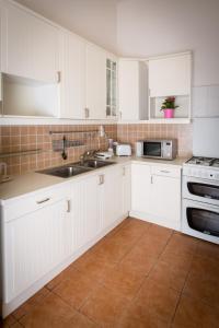 a kitchen with white cabinets and a sink at Historic Rooms near Gozsdu Udvar in Budapest