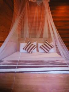 エッラにあるTalblick Homestay Ellaの蚊帳付きベッド(枕3つ付)