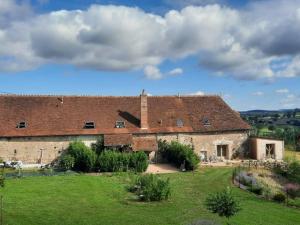 a large brick building with a grass field in front at Charmant Gîte Familial avec Piscine, Jardin et Aire de Jeux - Capacité 15 Pers, Blomard - FR-1-489-353 in Blomard